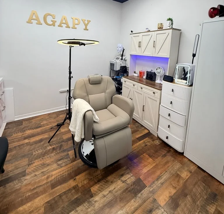 An Agapy Studio treatment room with the bed made up and the treatment lamp.