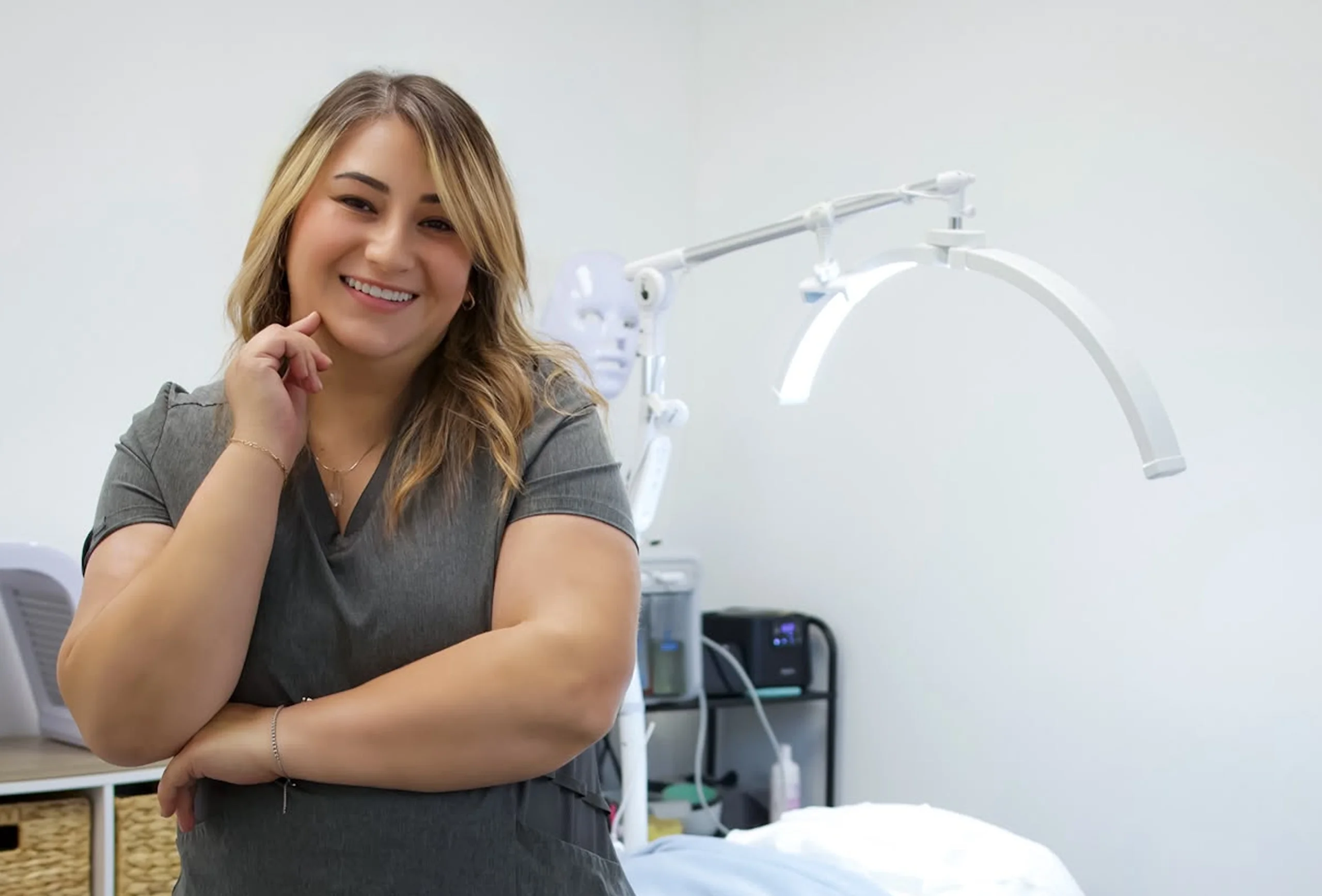 Paola smiling in the Agapy Studio treatment room, next to the treatment lamp.
